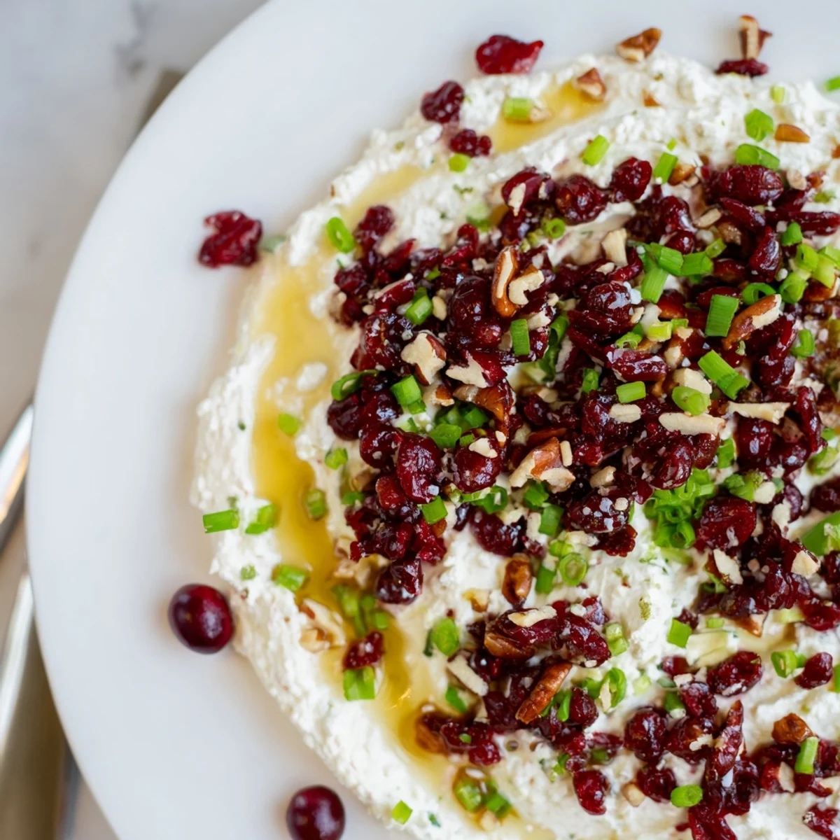 Vibrant cranberry jalapeño dip with honey drizzle, perfect for holiday gatherings.  