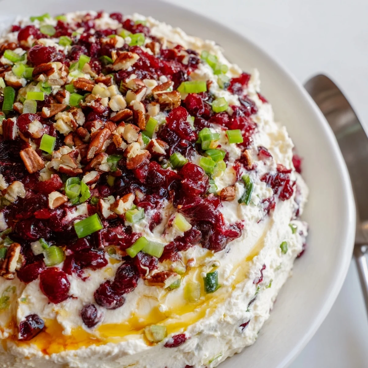 Festive appetizer featuring jalapeño-infused cranberry dip drizzled with sweet honey.