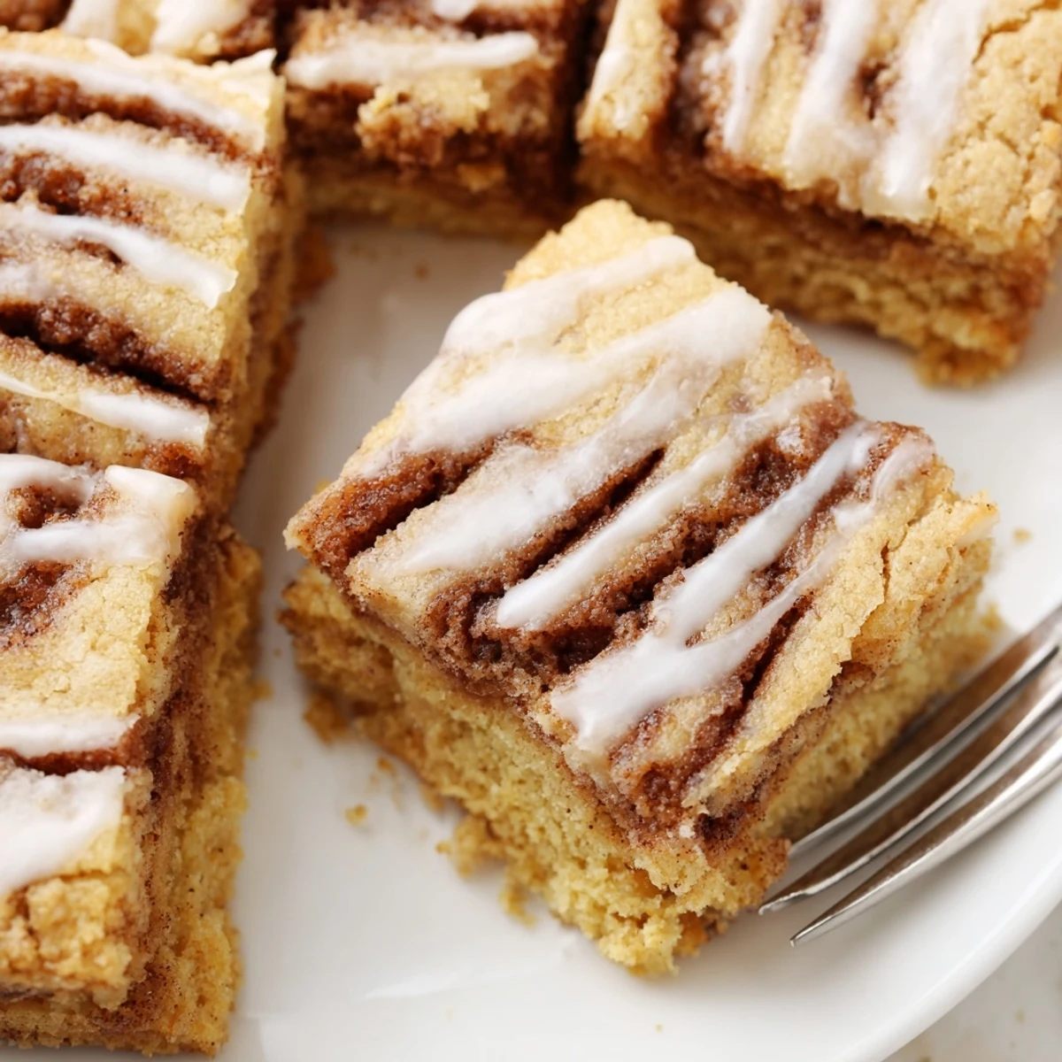 Soft Cinnamon Roll Cookie Bars topped with creamy glaze, perfect for dessert lovers.  
