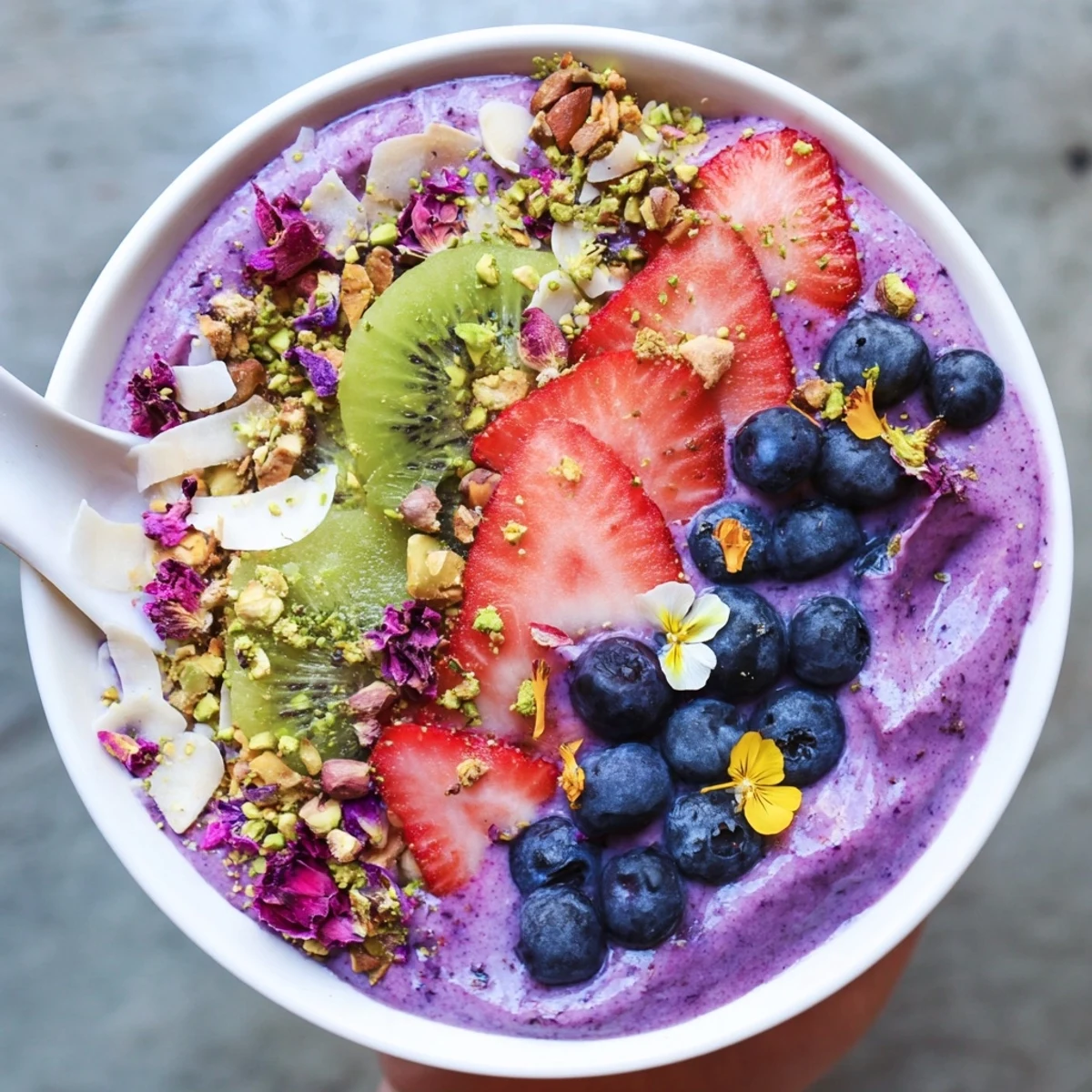 Vibrant smoothie bowls showcase purple yam and pistachios, topped with fresh fruits.  