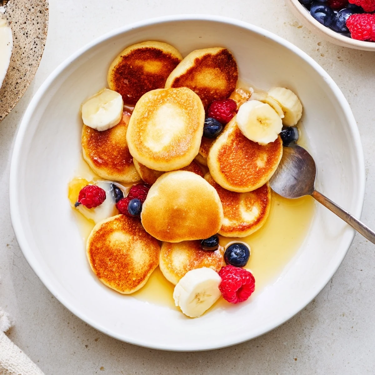 Delicious mini pancake cereal served with fresh berries and drizzled syrup.  