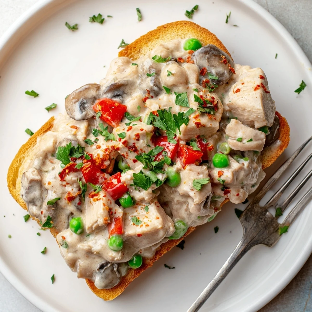 Savory Chicken à la King, bursting with veggies, ladled over crispy toasted bread slices.