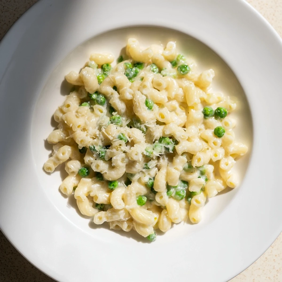 A close-up of delicious Macaroni & Peas, perfectly cooked with vibrant green peas and parmesan.