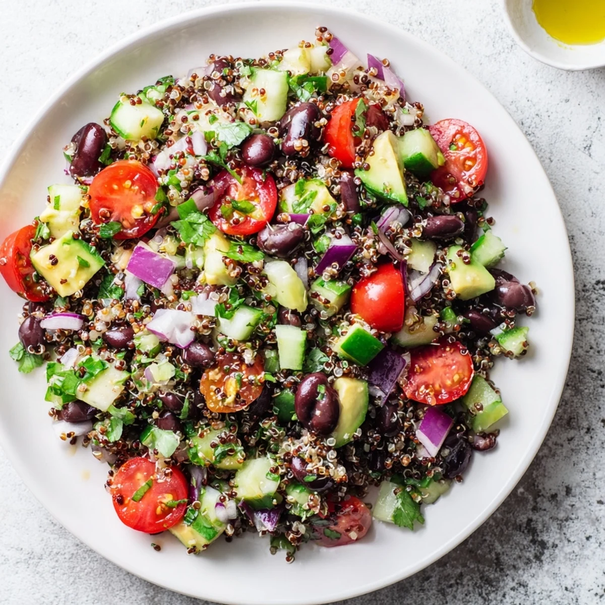A colorful bowl of Quinoa Black Bean Salad with juicy tomatoes and fresh cilantro.