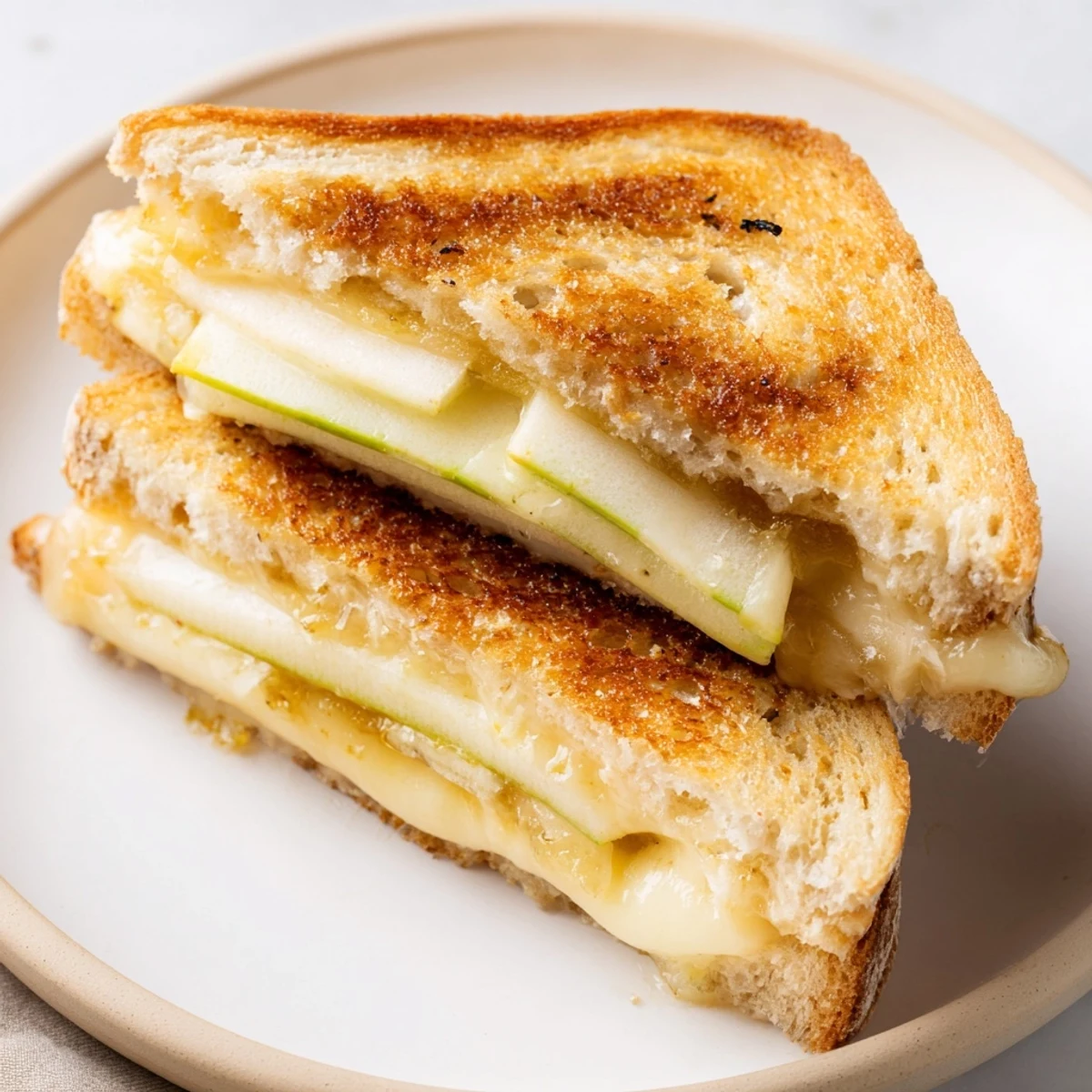 Crisp sourdough embracing melted Brie and apples - the ultimate gourmet grilled cheese recipe.