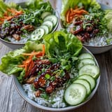 Bright Korean-inspired sesame turkey lettuce wrap bowls served with crisp lettuce, julienned carrots, and sesame seeds for scooping.