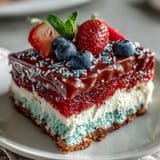 Festive Patriotic Poke Cake topped with fluffy whipped cream, ready for your celebration.