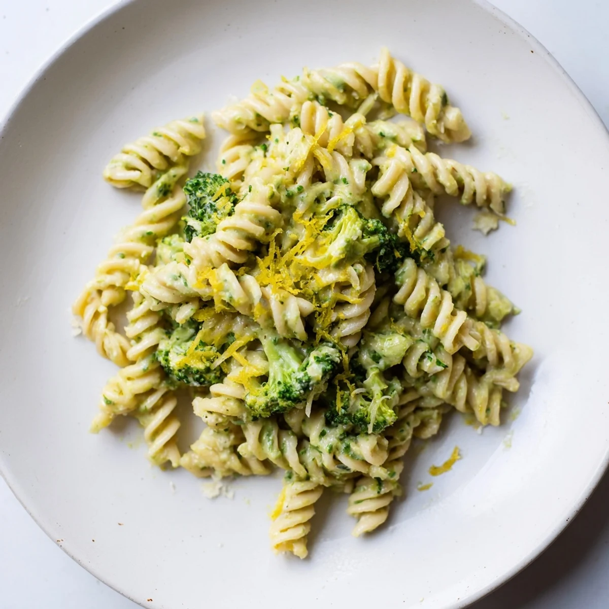 A vibrant bowl of Green Goddess Broccoli Cheddar One-Pot Pasta with melty cheese and fresh herbs.