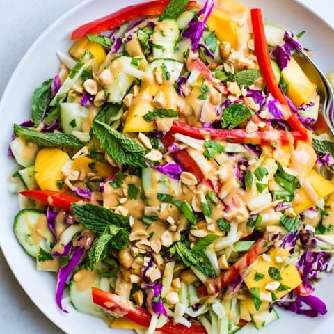 A bright, flavorful Thai Peanut Mango Veggie Salad with crunchy peanuts sprinkled on top.
