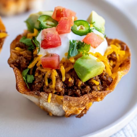 Golden, crispy mini taco cups filled with savory beef and bubbly, melted cheese.