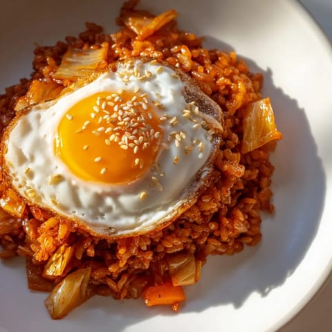 Vibrant kimchi fried rice with carrots and onions sizzling in a wok, ready to eat.