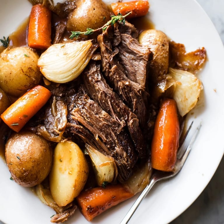 Hearty Sunday Pot Roast surrounded by vibrant roasted carrots and potatoes.  