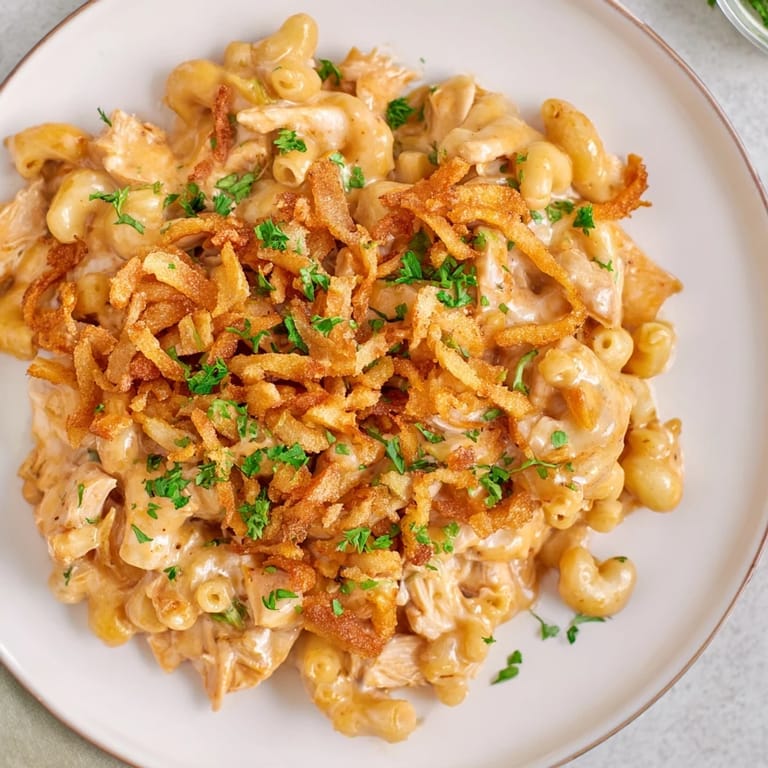 A close-up shot of creamy One-Pot Honey BBQ Chicken Mac and Cheese, topped with crispy onions.