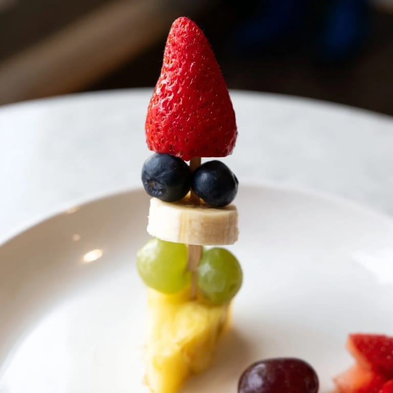 Vibrant Rocket Ship Fruit Skewers: stacked fruit shapes create a fun kids' snack with banana and blueberries.