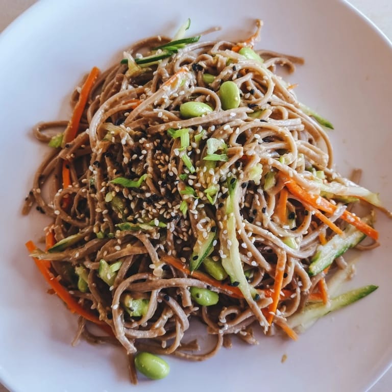 A chilled bowl of Asian sesame noodle salad with colorful vegetables, ready for a delicious meal.