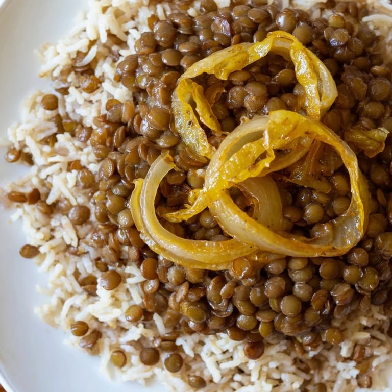 Golden crusty caramelized onions atop a steaming bowl of Lebanese Mjadra, ready to be enjoyed.