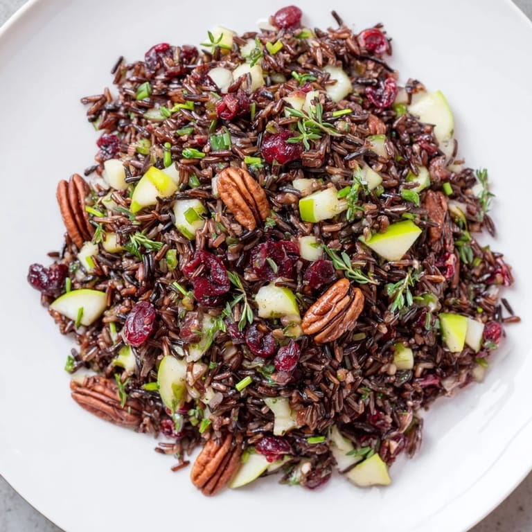 Enjoy a hearty wild rice harvest salad featuring sweet cranberries, crunchy pecans, and fresh flavors.