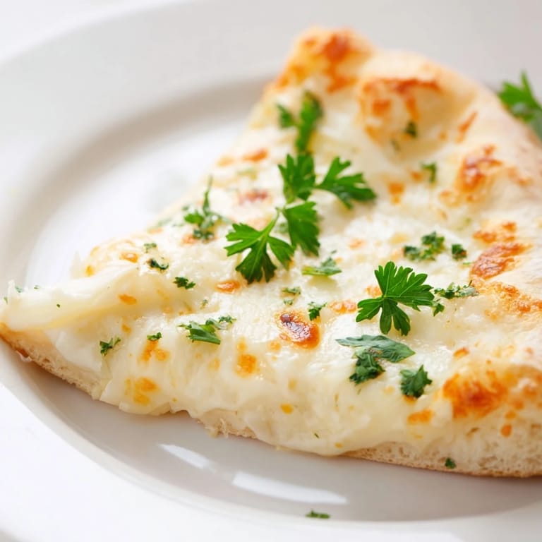 This vegetarian Creamy Garlic White Pizza is served hot from the oven, ready to be sliced and enjoyed for a comforting meal.